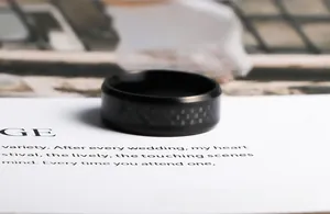 Gros plan sur une bague en acier noir avec texture en fibre de carbone tressée