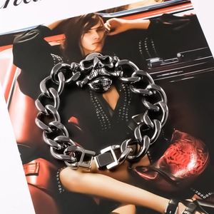 Detailed shot of chunky punk skull bracelet with heavy silver Cuban chain links