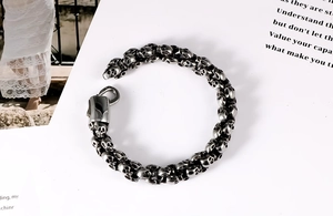 Detailed view of vintage silver skull links on a stainless steel bracelet with lobster clasp