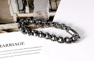 Detailed view of punk style stainless steel skull link bracelet with vintage silver finish