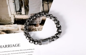 Macro detail of gothic skull link bracelet with secure square clasp in polished steel