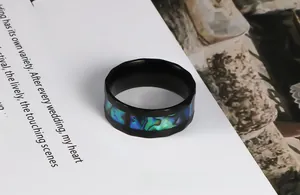 Detail of black faceted stainless steel ring featuring colorful abalone shell inlay