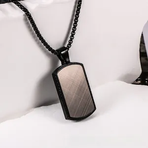 Detail shot of men's industrial square pendant with brushed metal finish on stone