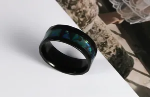 Detailed close-up of faceted black stainless steel ring with abalone shell inlay