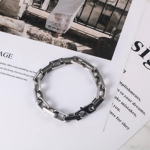 Macro detail of industrial silver square link stainless steel bracelet with sleek clasp