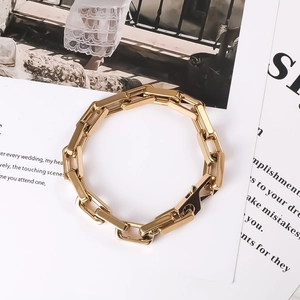 Detailed close-up of thick gold-plated titanium steel square link chain bracelet