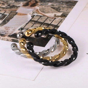 Detailed view of woven twisted metal cuff bracelets in gold, silver and black finishes
