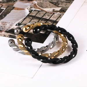 Detailed view of woven mesh twisted open bangles in gold, silver, and black finishes