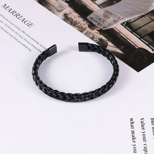 Detail of black twisted cable cuff bracelet with polished square metal end caps