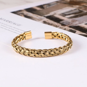 Detail of twisted cable gold bracelet showing intricate braided texture and metal finish