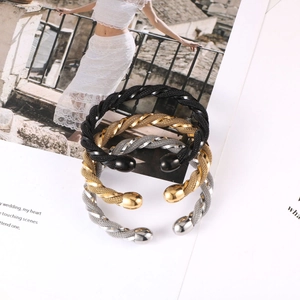 Three-piece twisted cable bangle set in black, gold and silver finish with ball ends