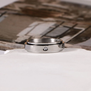 Minimalist spinning stainless steel couple ring with a single centered diamond accent