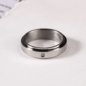 Macro view of minimalist rotating stainless steel ring with a small inlaid diamond