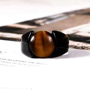 Macro shot of tiger eye stone set in polished black stainless steel ring for men