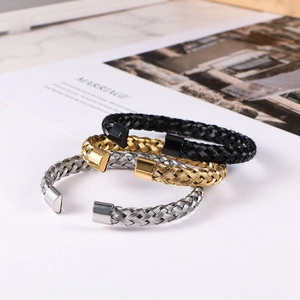 Three twisted stainless steel cable bracelets in black, gold, and silver finishes