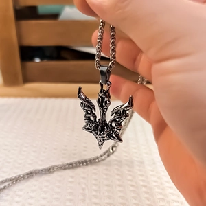 Vue détaillée du pendentif trident tête de mort gothique avec texture de métal oxydé