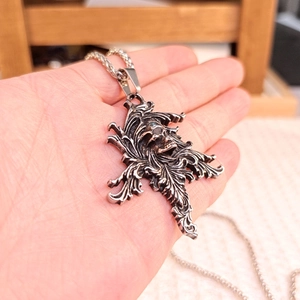Macro shot of gothic skull pendant with vintage silver finish and twisted rope chain