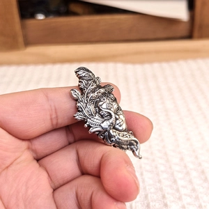 Retro silver ethnic mask pendant with layered feather textures in a vintage gothic style