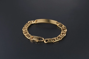 Macro shot of polished gold-plated H-link bracelet with an engravable metal plate