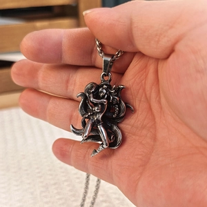 Detailed close-up of a vintage silver nine-tailed fox pendant with heavy rope chain necklace