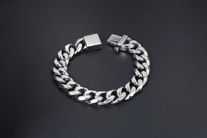 Macro view of heavy silver Cuban link chain bracelet with a sturdy square clasp for men