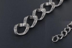 Détail du bracelet tête de mort vintage avec maillons gravés et finition argentée