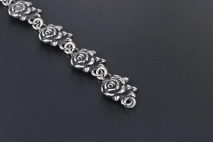 Detailed macro view of vintage stainless steel bracelet with ornate rose flower links