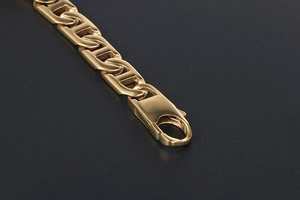Close-up of gold-plated bracelet showing the lobster clasp and flat geometric chain links