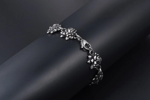 Close-up of vintage rose-shaped links on a stainless steel bracelet with lobster clasp