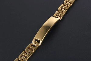 Macro detail of polished gold-plated stainless steel bracelet with custom H-link design