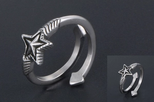 Macro detail of silver pentagram ring with arrow feather texture and retro industrial finish