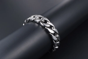 Detailed close-up of a polished stainless steel Cuban link bracelet with a mirror finish