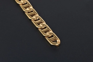 Macro detail of polished gold-plated mariner link chain with smooth metallic finish