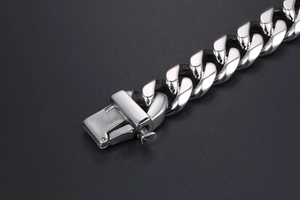 Detailed close-up of polished titanium steel cuban link bracelet with secure clasp