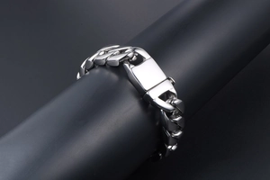 Close-up of polished stainless steel Cuban link bracelet with rectangle clasp on a display