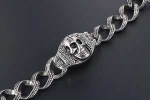 Vue macro du bracelet gothique tête de mort avec maillons gravés et détail de croix