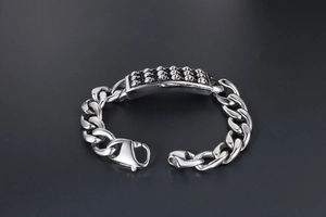 Dettaglio del bracciale a catena in acciaio inossidabile con rilievi di teschi