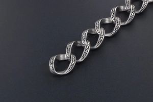 Gros plan d'un bracelet rock tête de mort avec chaîne torsadée argentée et gravures