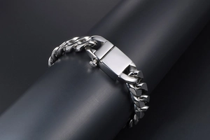 Macro shot of silver titanium steel curb chain bracelet with large clasp on black display
