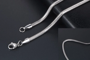 Close-up detail of silver snake bone chain necklace featuring a secure lobster clasp