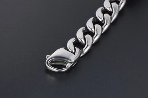 Vista macro di un bracciale a catena cubana in acciaio argento con chiusura a moschettone
