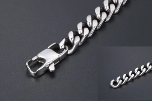 Detalle macro de pulsera de cadena plana de acero inoxidable con cierre de langosta