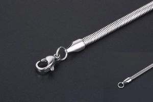 Detail of silver snake chain with a secure lobster clasp closure on a dark background