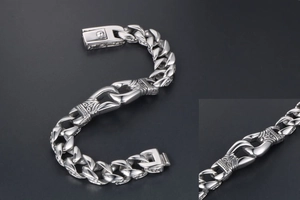 Detailansicht eines silbernen Panzerarmbands im Punk-Stil mit Vintage-Gravuren