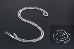 Detailed macro view of flat silver snake bone chain with lobster clasp and sleek finish