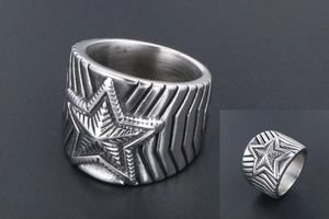 Détail macro d'une bague étoile en acier pour homme avec textures et bords rainurés