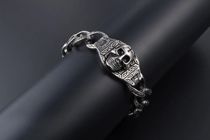 Détail du bracelet tête de mort rock vintage avec gravures tribales et chaîne gourmette