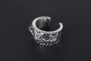 Detailed macro view of vintage stainless steel wide ring with engraved star pattern