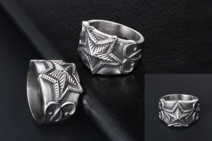 Detailed view of a vintage silver star ring with intricate relief engraving on the sides