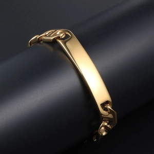 Polished gold curb chain bracelet with a smooth rectangular bar on a black display stand